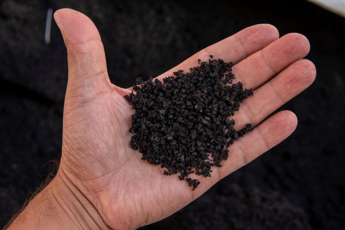 person holding shredded rubber in hand